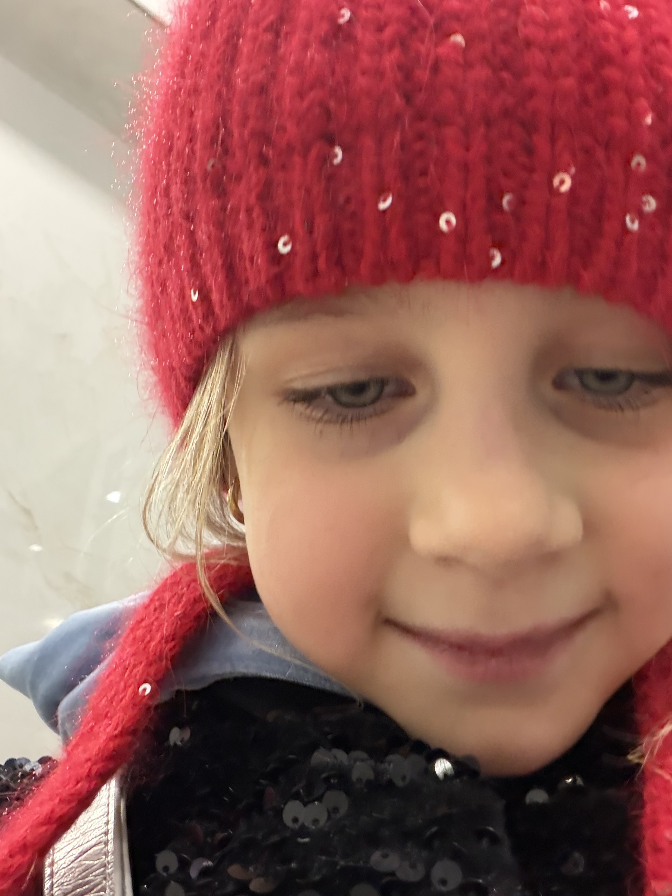Милая девочка в красной шапке со стразами