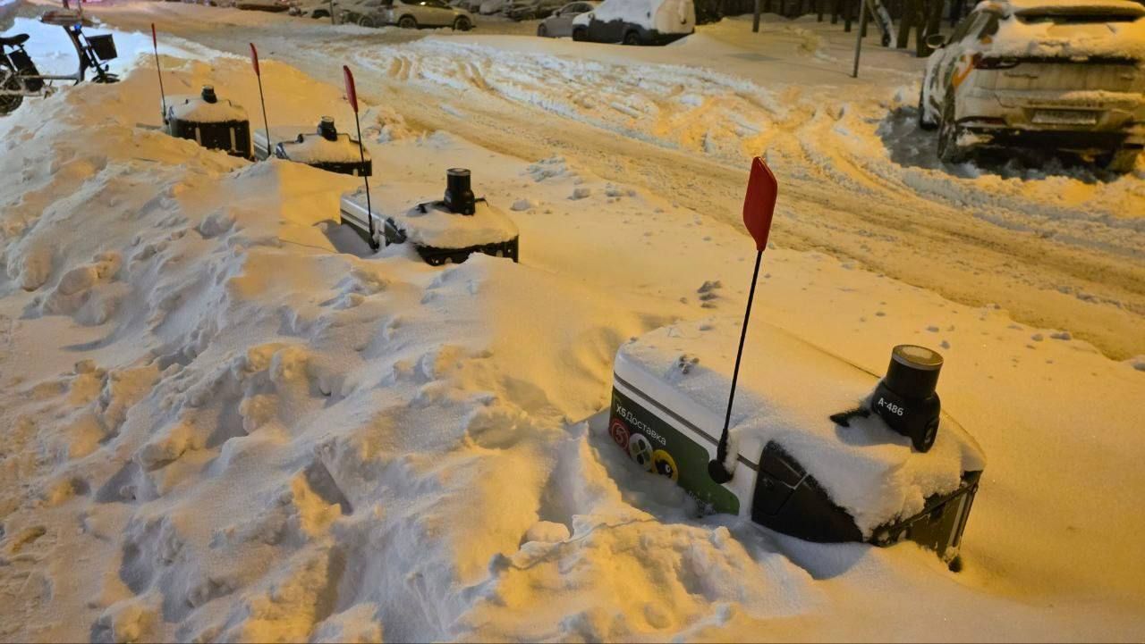 Заснеженная улица с почтовыми ящиками и припаркованными авто