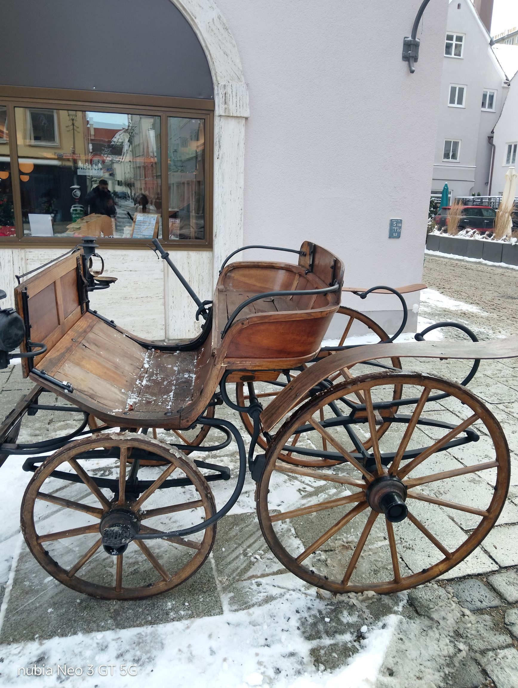 Старинная повозка у здания зимой