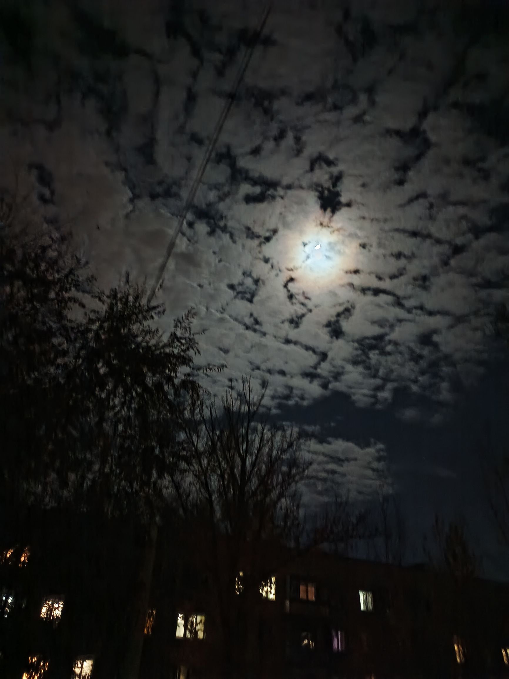 Ночное небо над домами, луна сквозь облака.