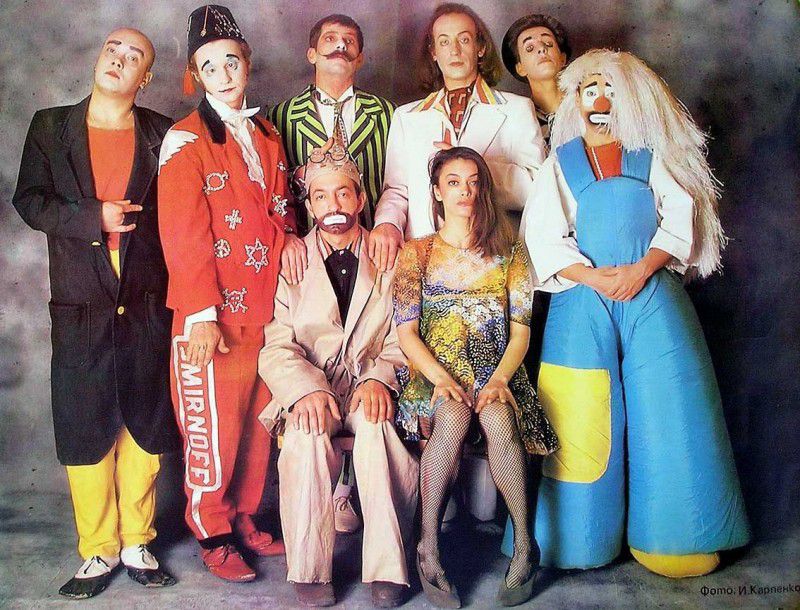 Группа людей в ярких костюмах и покерных позах, фигуры стоят рядом