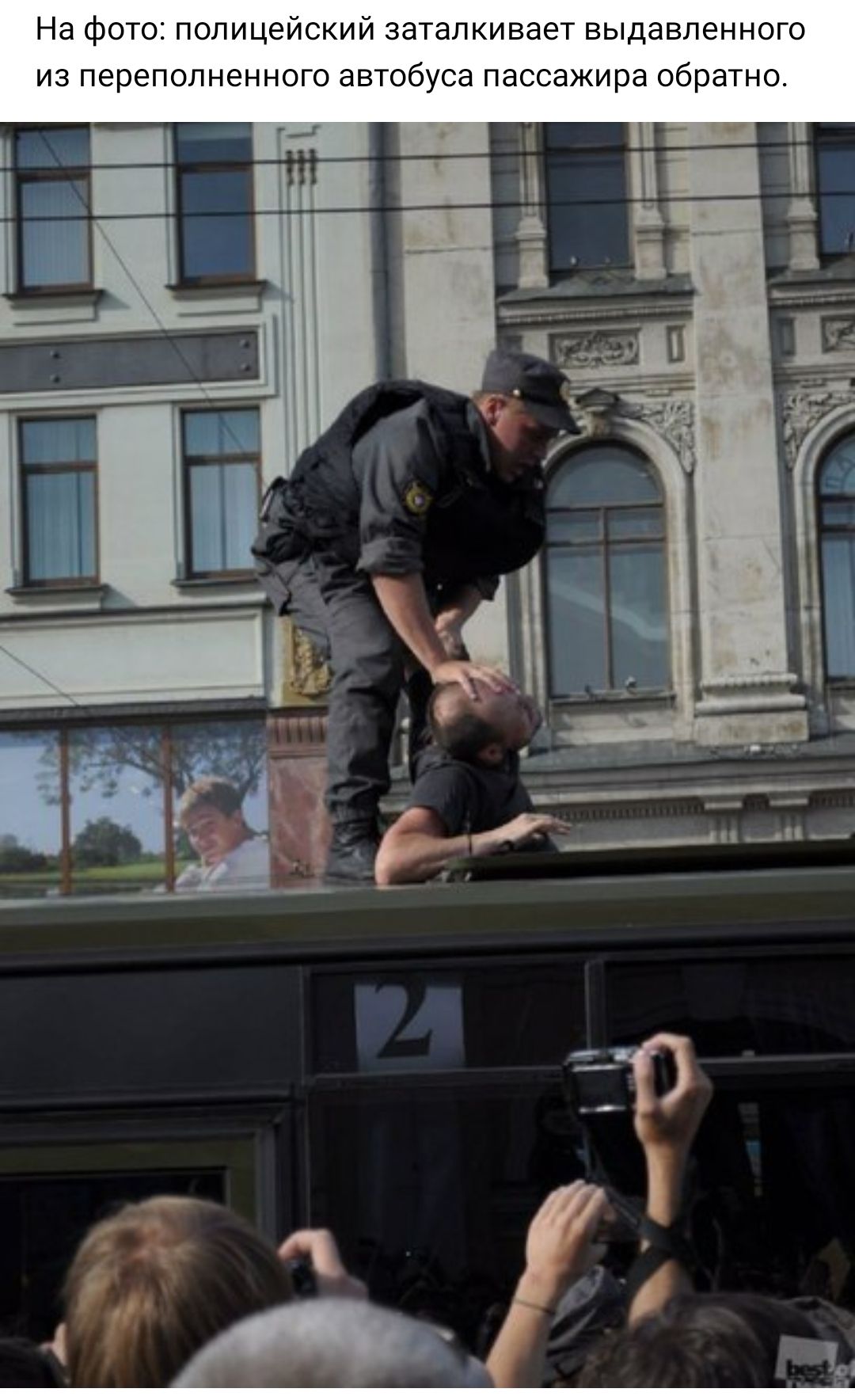 На фото полицейский заталкивает выдавленного из переполненного автобуса пассажира обратно