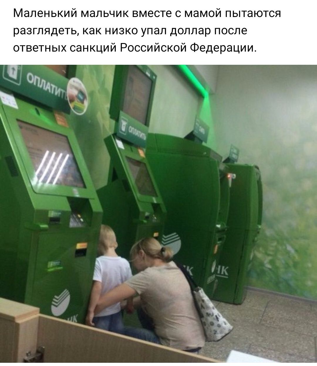 Маленький мальчик вместе с мамой пытаются разглядеть как низко упал доллар после ответных санкций Российской Федерации