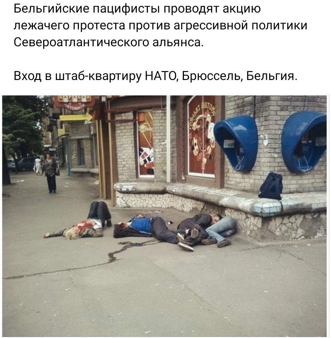 Бельгийские пацифисты проводят акцию лежачего прстеста прстиа агрессивной политики Североатпаитического альянса Вход в штабгквартиру НАТО Брюссель Бельгия