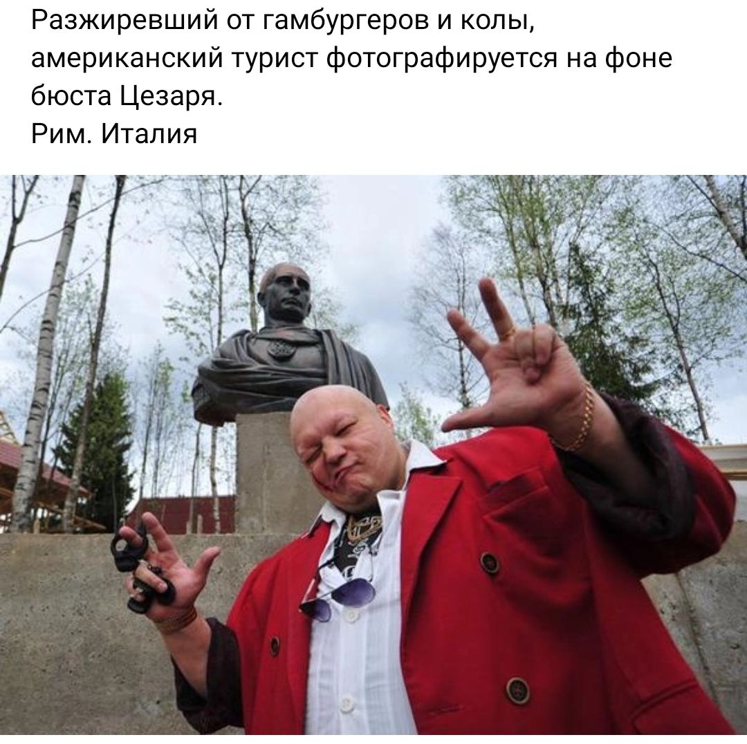 Разжиревший от гамбургеров и опы американский турист Фотаграфируется на фоне бюста Цезаря Рим Италия