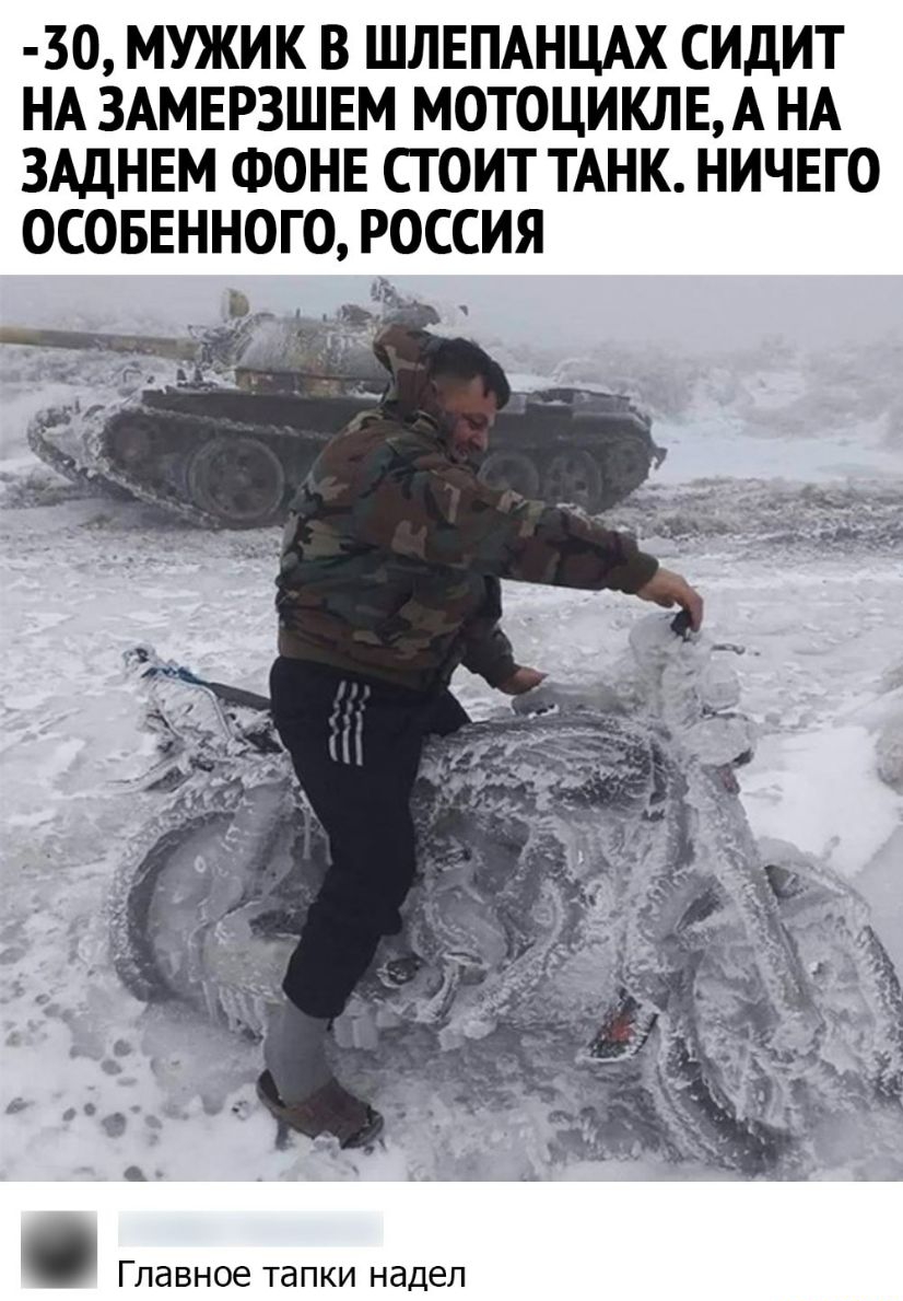 ЗО МУЖИК В ШЛЕПАНЦАХ СИДИТ НА ЗАМЕРЗШЕМ МОТОЦИКЛЕА НА ЗАДНЕМ ФОНЕ СТОИТ ТАНК НИЧЕГО ОСОБЕННОГО РОССИЯ Главное тапки надел