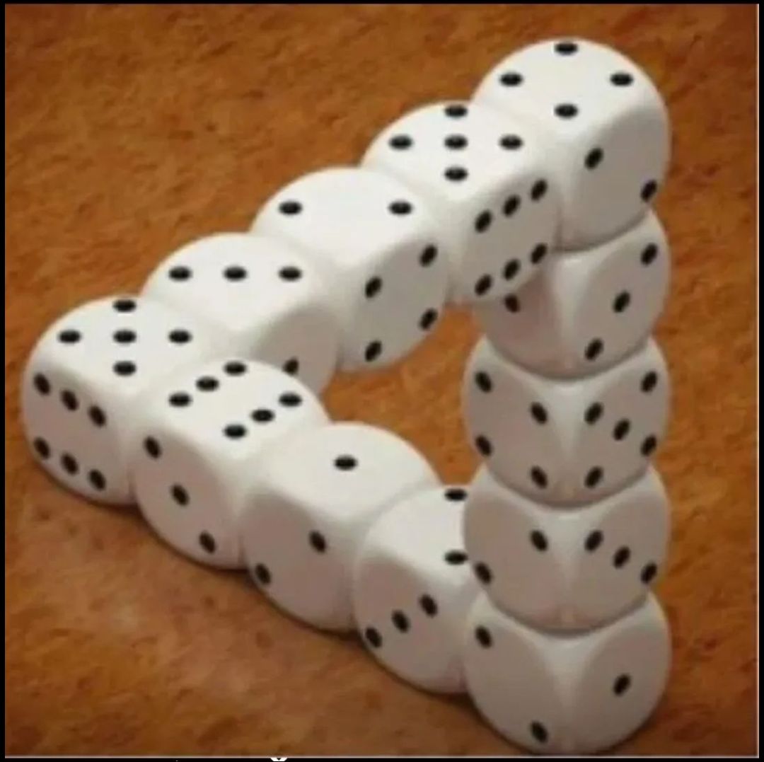 Белые игральные кубики (домино) образуют фигуру, стоящие и лежащие кубики на коричневой поверхности.