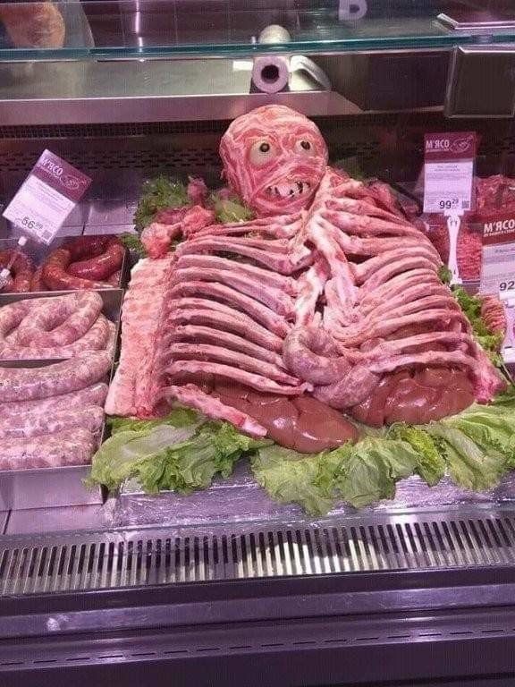 Изображение необычного мясного изделия, оформленного в виде скелета с головой.