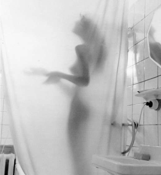 Силуэт обнажённого человека за душевой занавес в ванной.