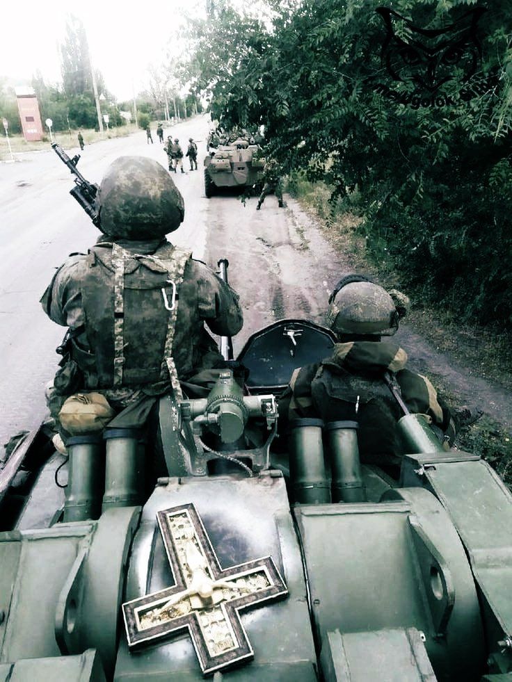 Военные на бронетранспортере с солдатами на проселочной дороге