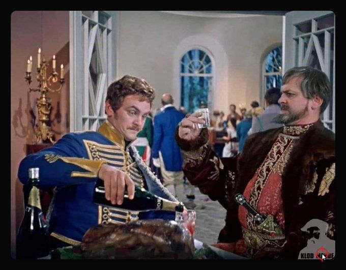 Два мужчины в роскошных костюмах наливают вино на торжественной вечеринке.