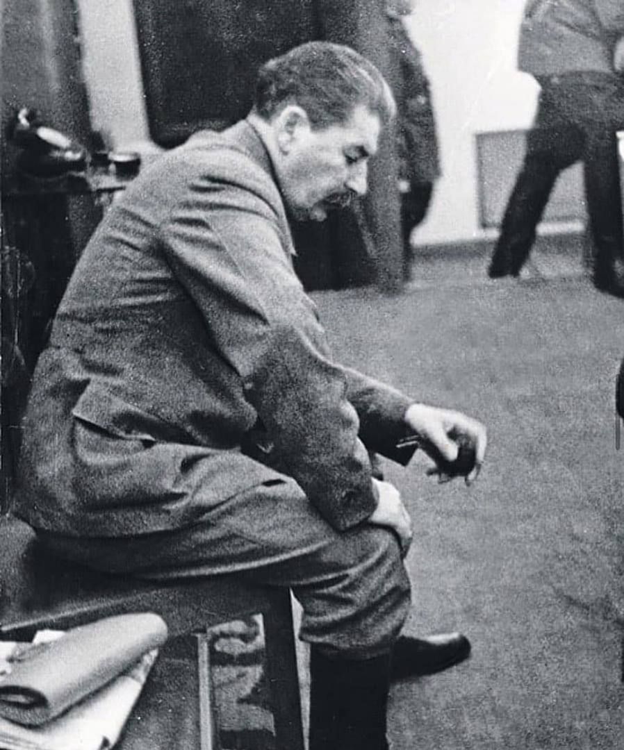 Чёрно-белое фото мужчины в костюме, сидит на чем-то, возможно эпоха СССР.