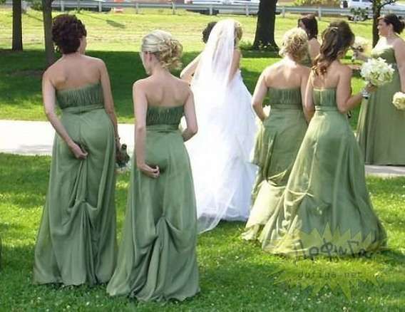 Невеста в белом идёт с подружками в зелёных платьях по газону парка