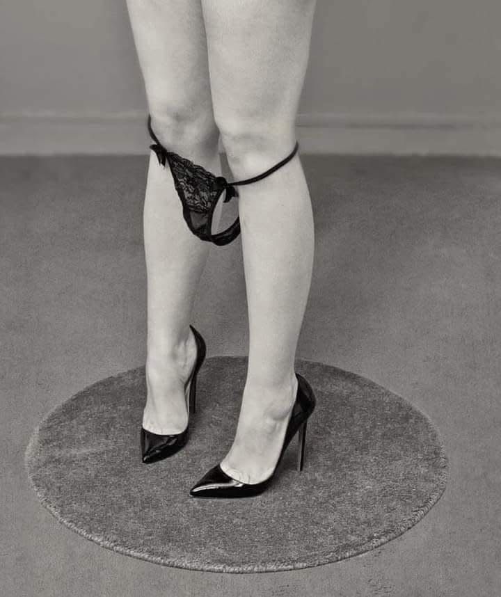 Фото нижней части тела женщины в чулках и подвязке в туфлях на полу
