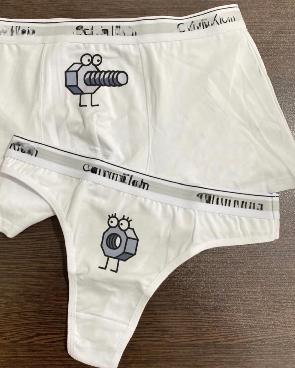 Calvin Klein (логотип повторяется на резинке) и принт с маленьким мультяшным существом на белых трусах/тонких мужских-женских боксерках.