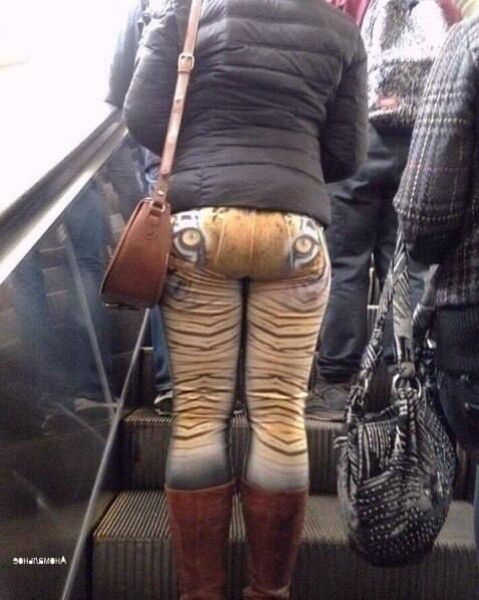 Человек на эскалаторе в штаны с рисунком под тигра.